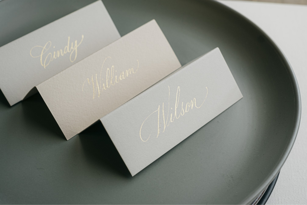 Folded place cards in gold copperplate calligraphy